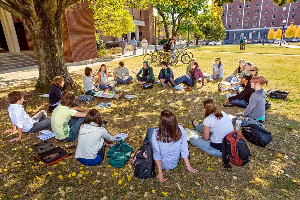 Students sitting outside in circle discussing lesson